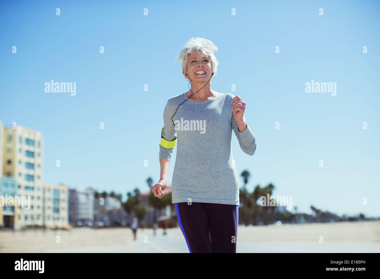 Senior woman power walking on beach Stock Photo