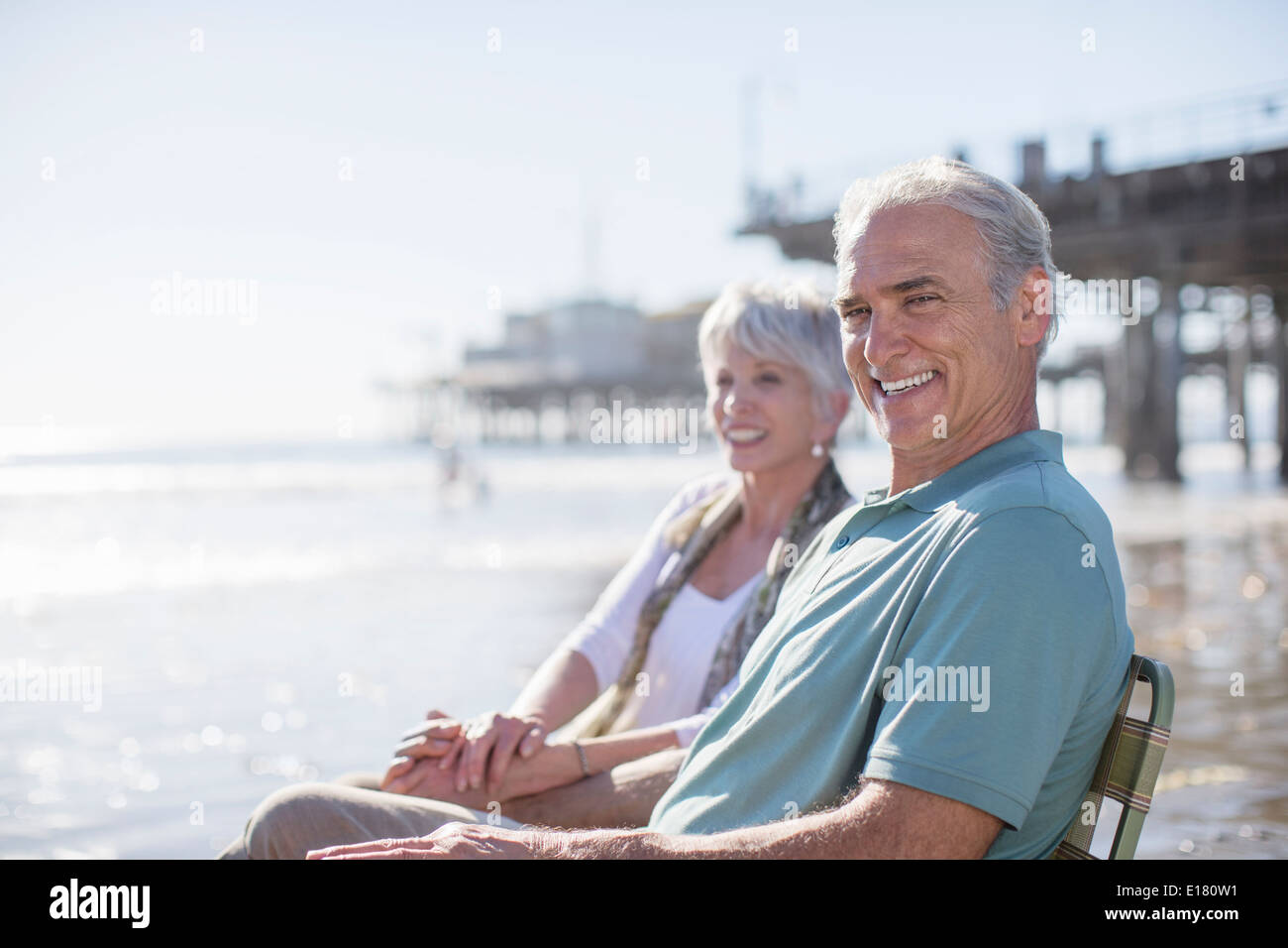 Portrait of senior couple relaxing on sunny beach Stock Photo