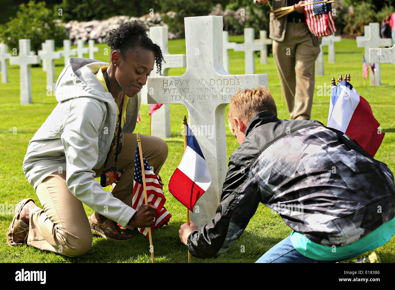 French and American children place flags at the graves of soldiers during a ceremony to mark the 96th anniversary of the historic Battle of Belleau Wood and Memorial Day at Aisne-Marne American Cemetery May 24, 2014 in Belleau, France. Stock Photo