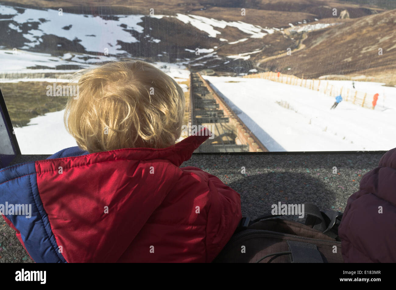 dh Cairngorm National Park AVIEMORE INVERNESSSHIRE child looking out of funicular railway train at track skiers scotland snow Stock Photo