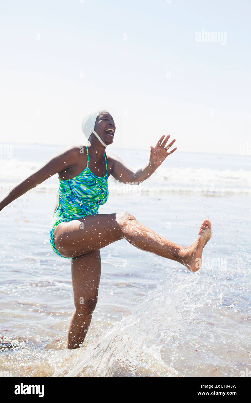 Woman splashing in ocean surf Stock Photo
