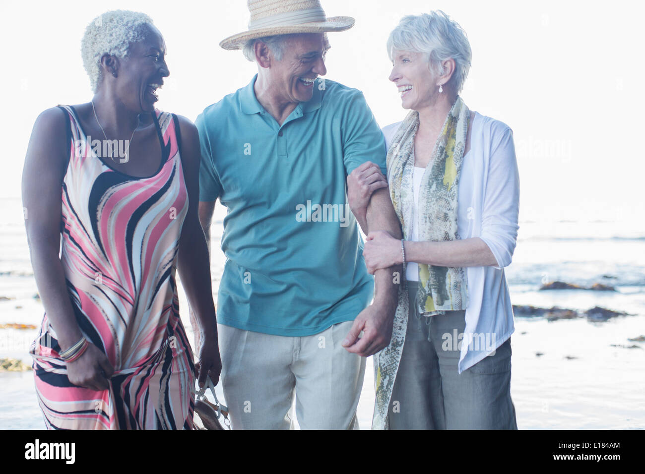 Senior friends walking on beach Stock Photo