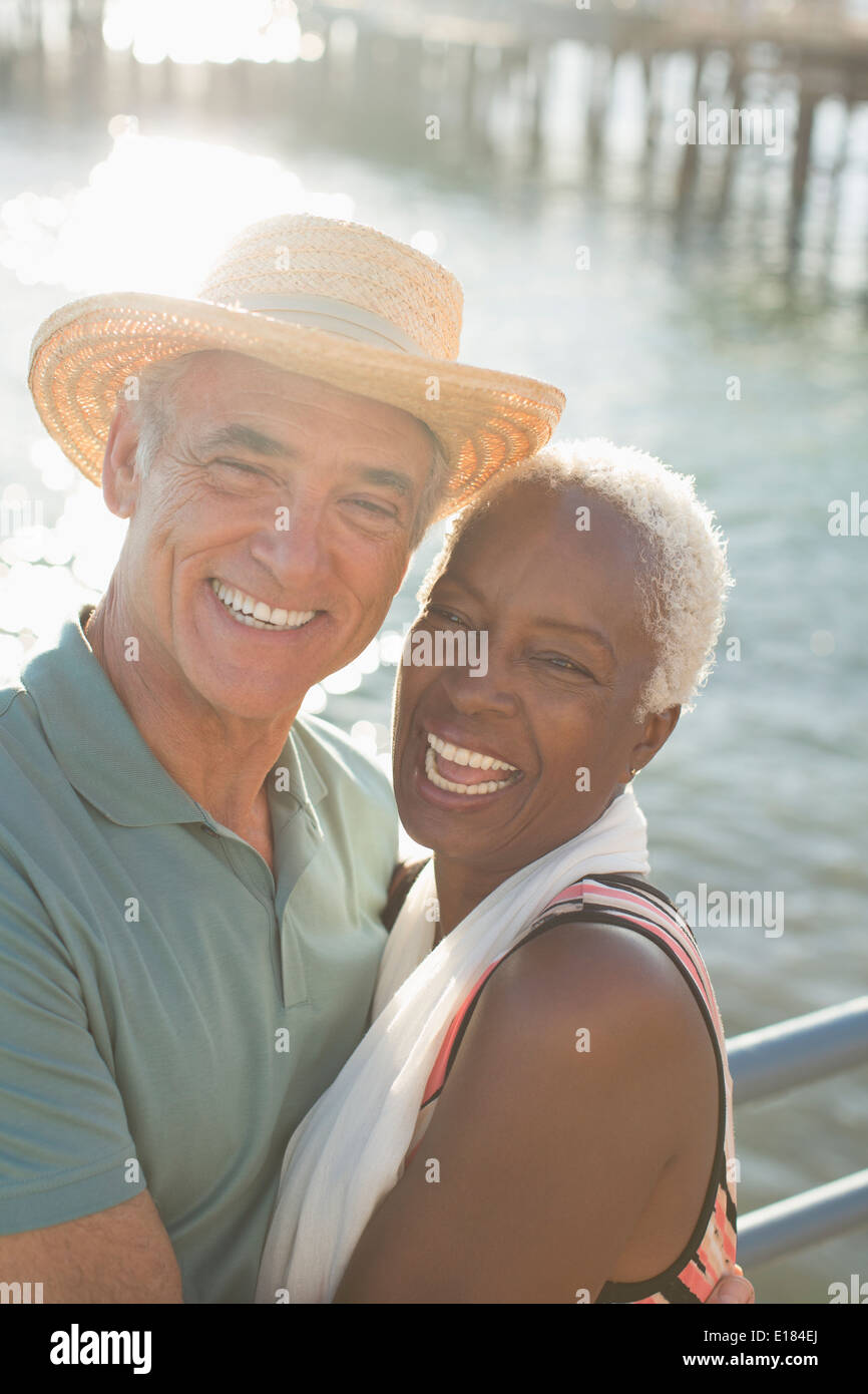 Portrait of enthusiastic couple hugging at oceanfront Stock Photo