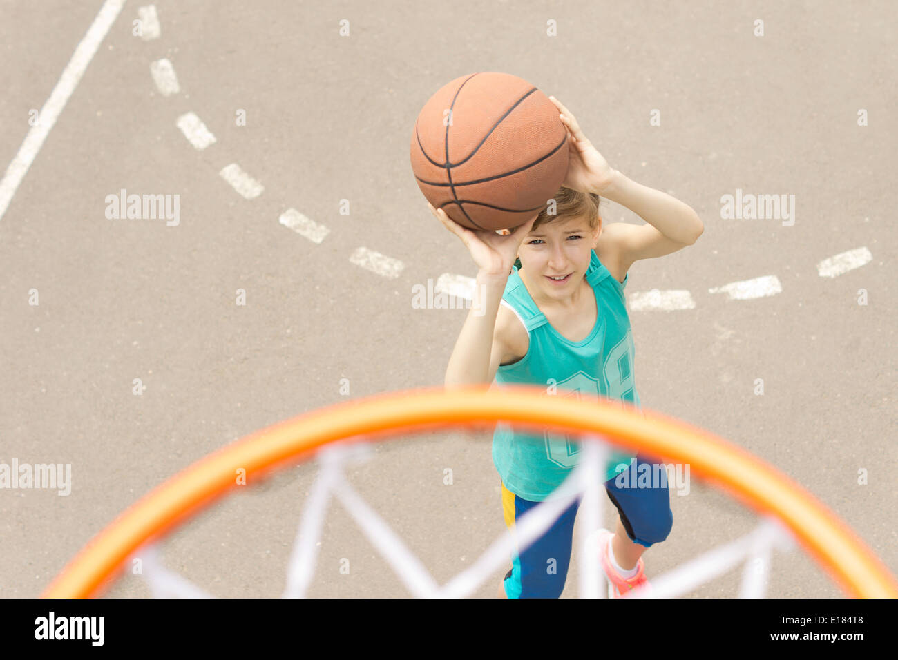 Young girl taking aim at the goal on a basketball court standing with the  ball raised aiming at the hoop Stock Photo - Alamy