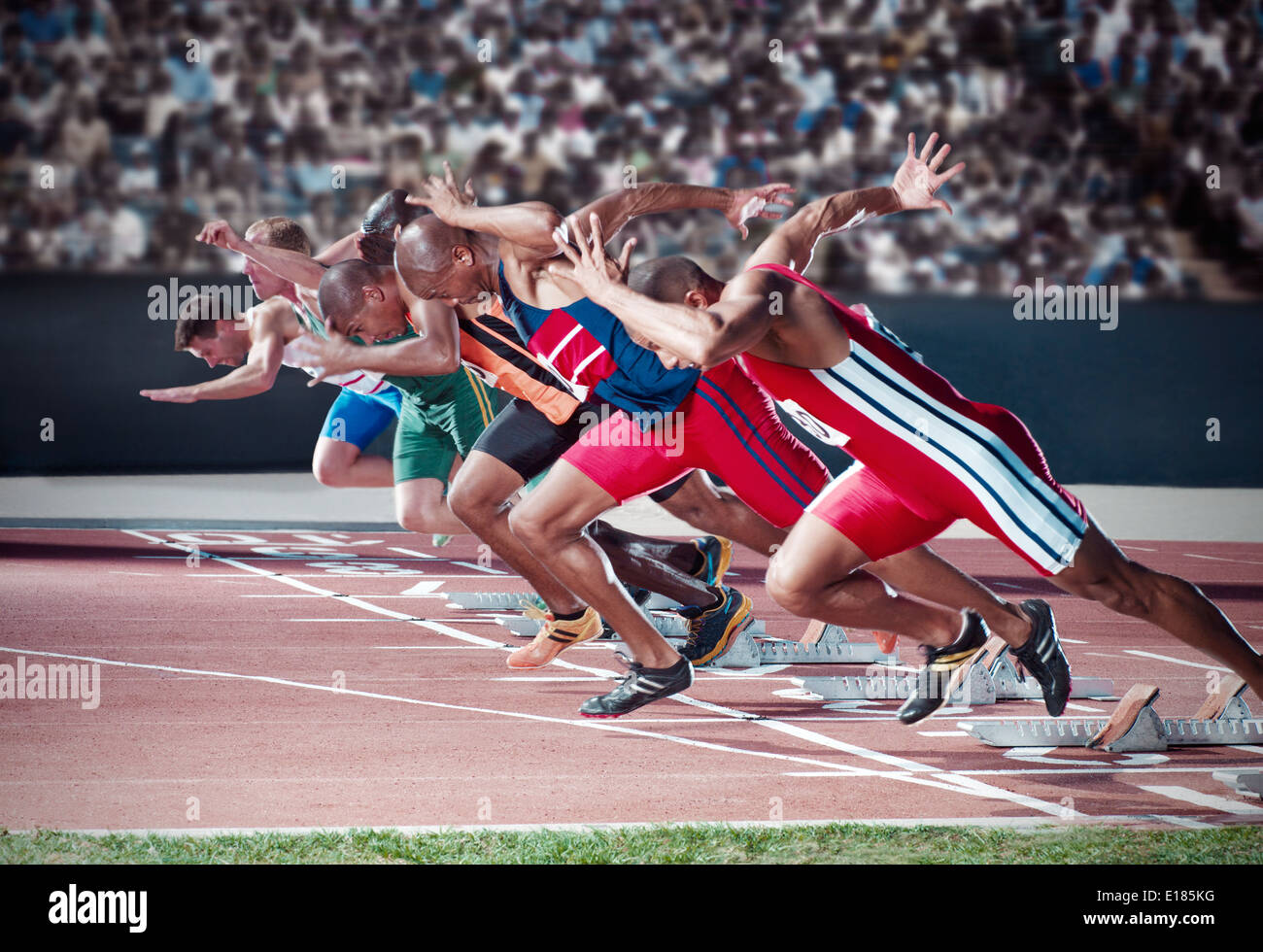 Runners taking off from starting blocks on track Stock Photo