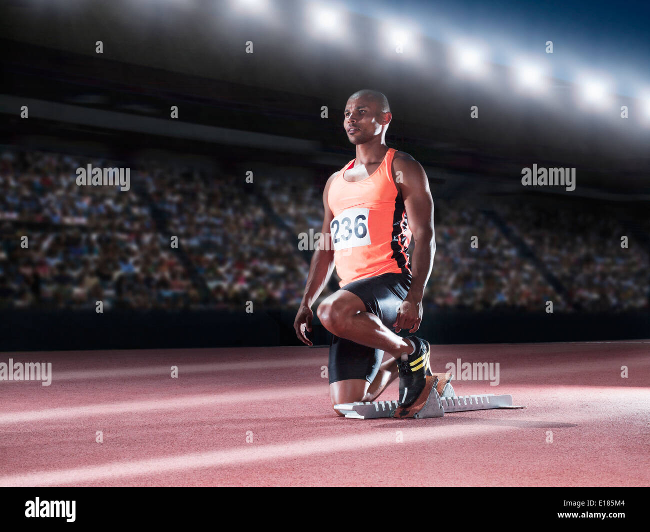 Runner with feet in starting block on track Stock Photo