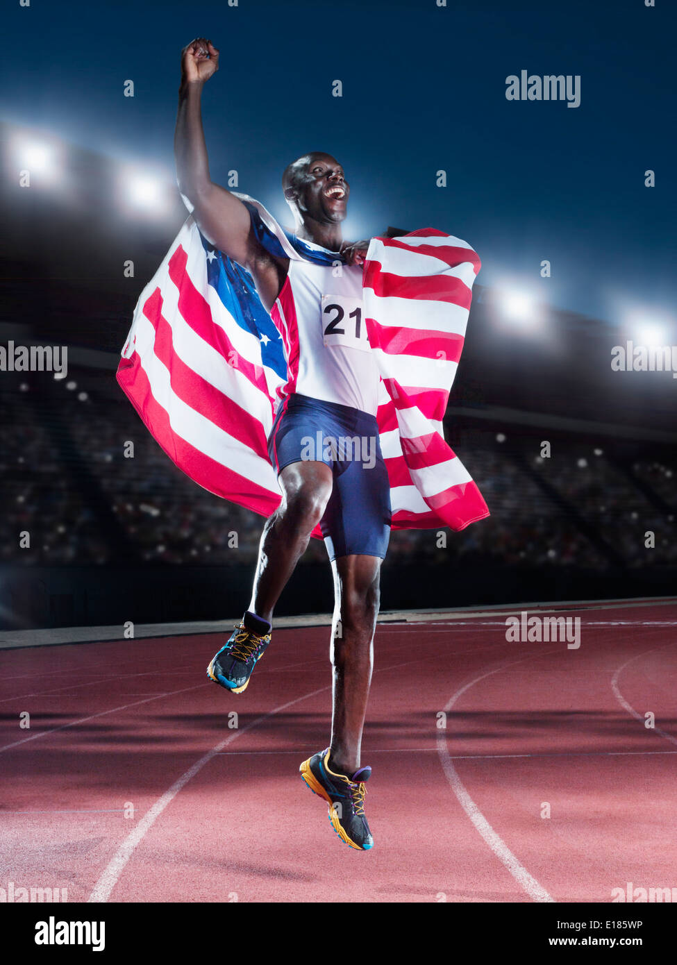 Runner holding American flag and celebrating on track Stock Photo