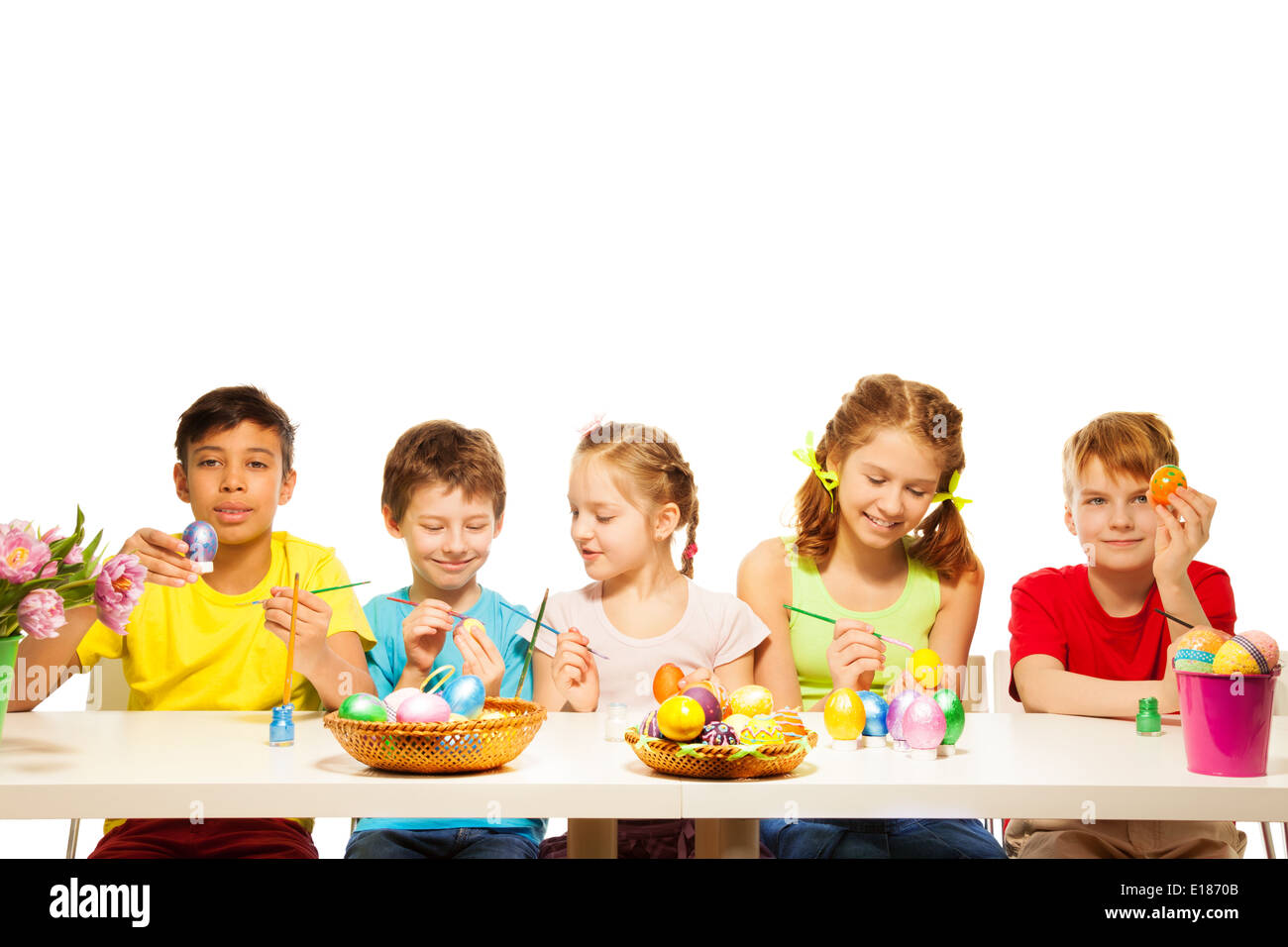 Five kids with colourful Eastern eggs at table Stock Photo