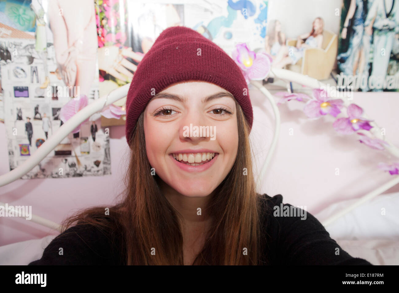 Teenage 13 year old girl posing for a pretend selfie in her bedroom