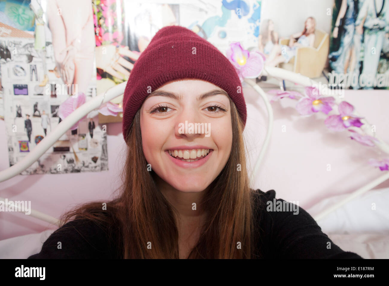 Teenage 13 year old girl posing for a pretend selfie in her bedroom Stock Photo