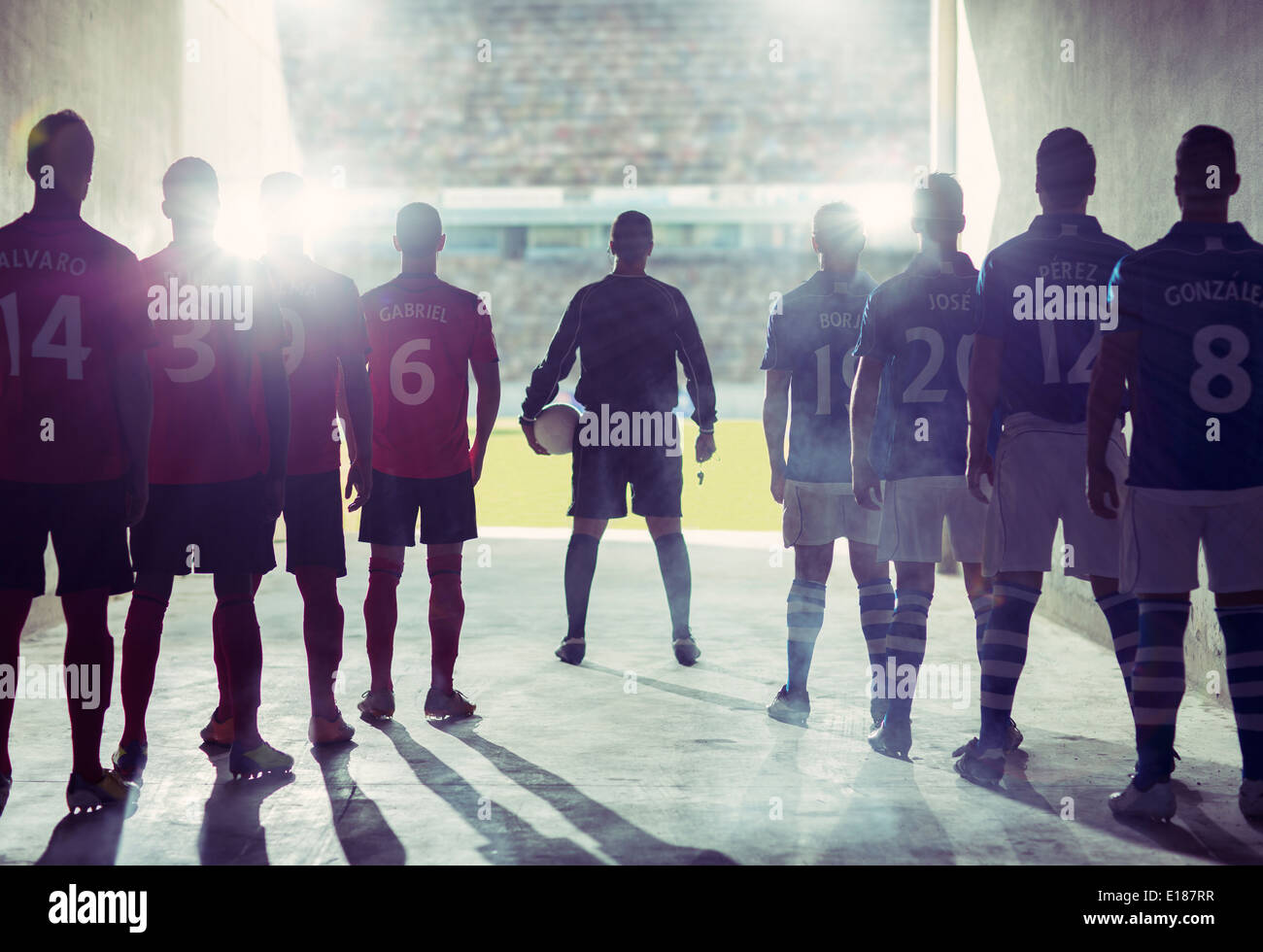 Silhouette of soccer teams facing field Stock Photo
