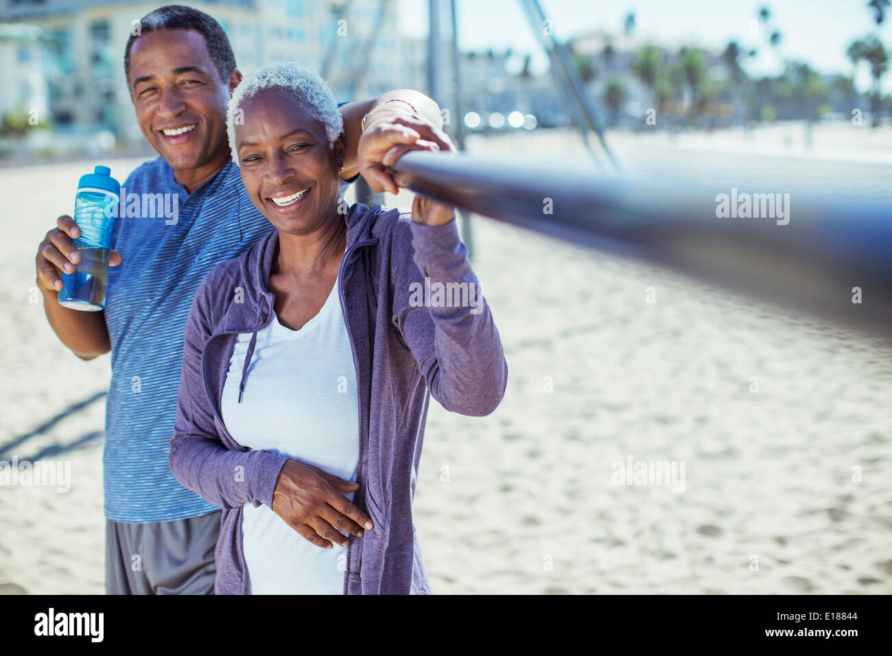 Portrait of smiling senior couple on beach playground Stock Photo