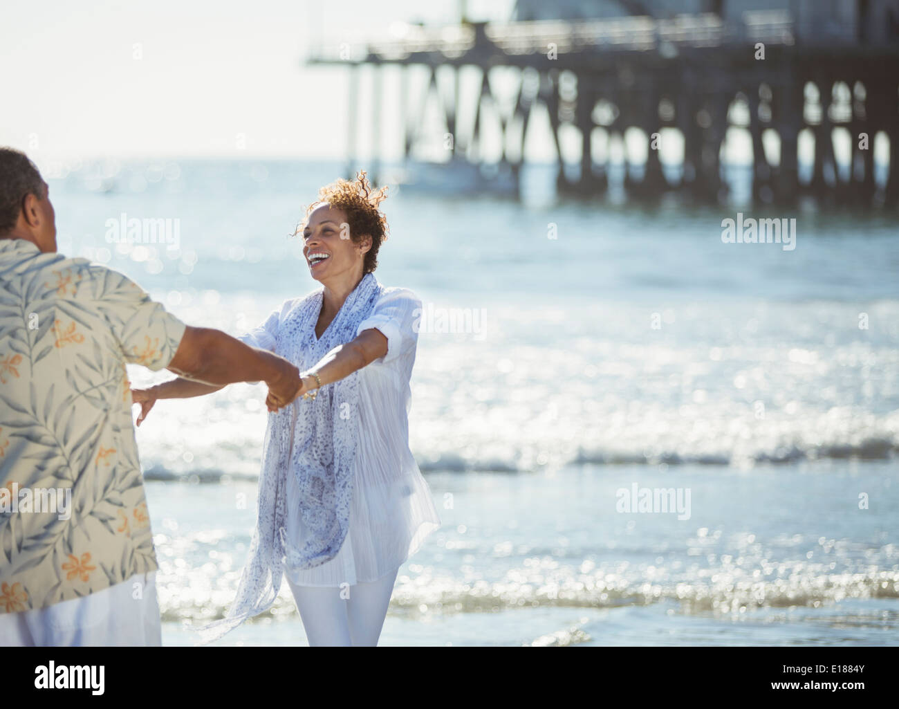 Enthusiastic couple dancing on sunny beach Stock Photo