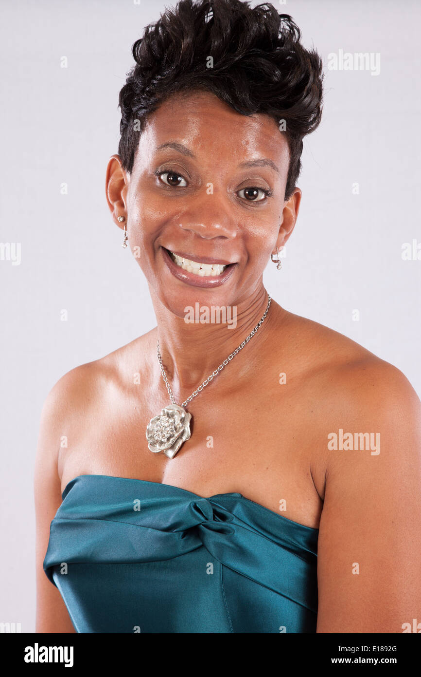 Pretty black woman in dress without shoulders smiling at the camera with a friendly pleased expression Stock Photo Alamy