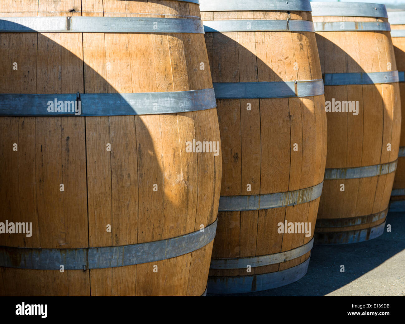 Wine barrels are stacked in a row at a winery in Napa, California Stock