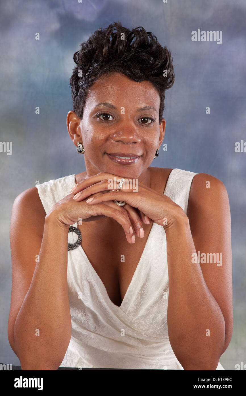 Pretty black woman in white dress, smiling at the camera with a friendly, happy smile Stock Photo