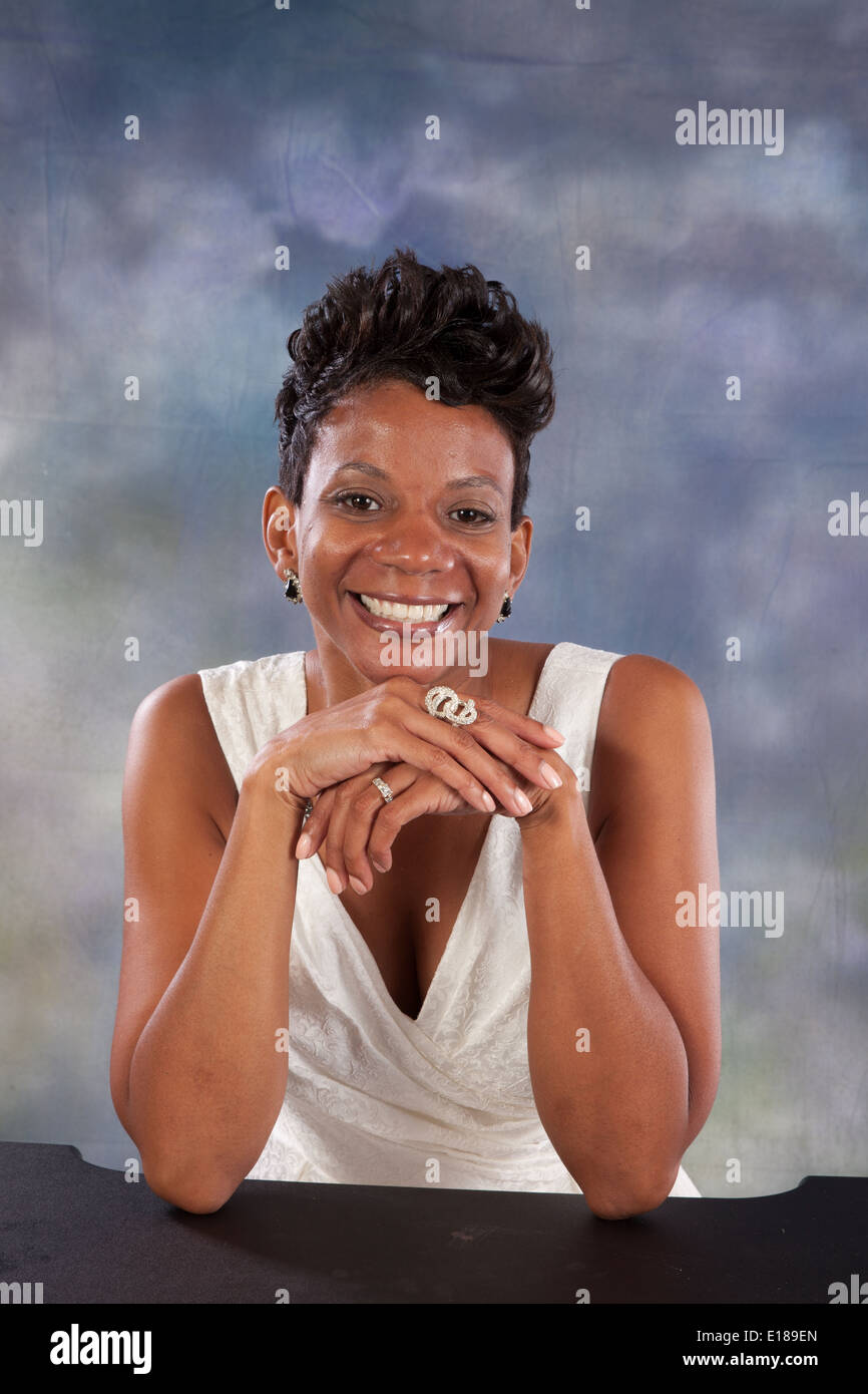 Pretty black woman in white dress, smiling at the camera with a friendly, happy smile Stock Photo
