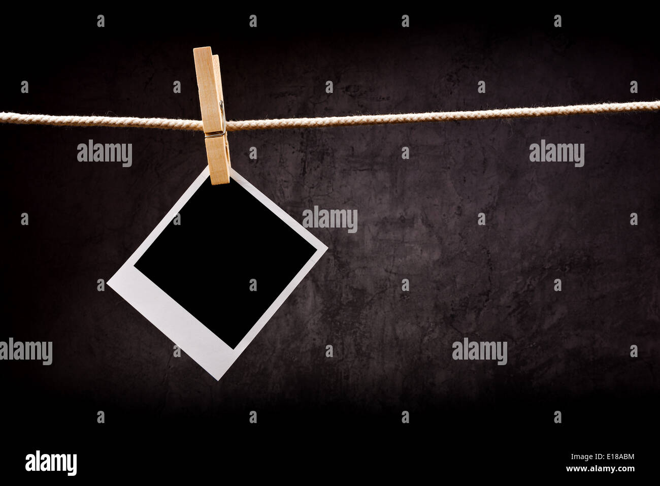 Photography paper with instant photo frame attached to rope with clothes pins. Copy space for your image. Stock Photo