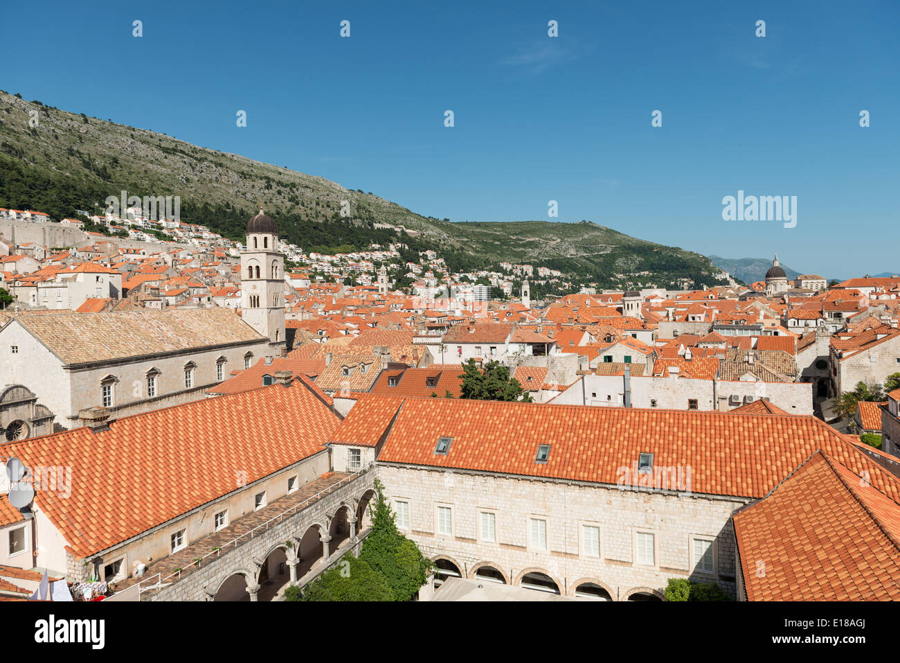 Red rooftops of the old town of Dubrovnik with mountains in the background - Dubrovnik, Croatia Stock Photo