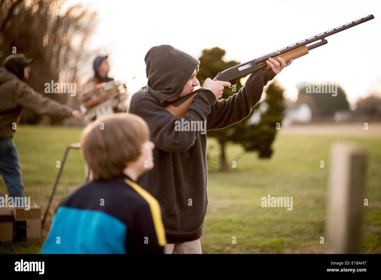 Young man holding rifle, aiming for a clay disc in Bel Air, Maryland,USA Stock Photo