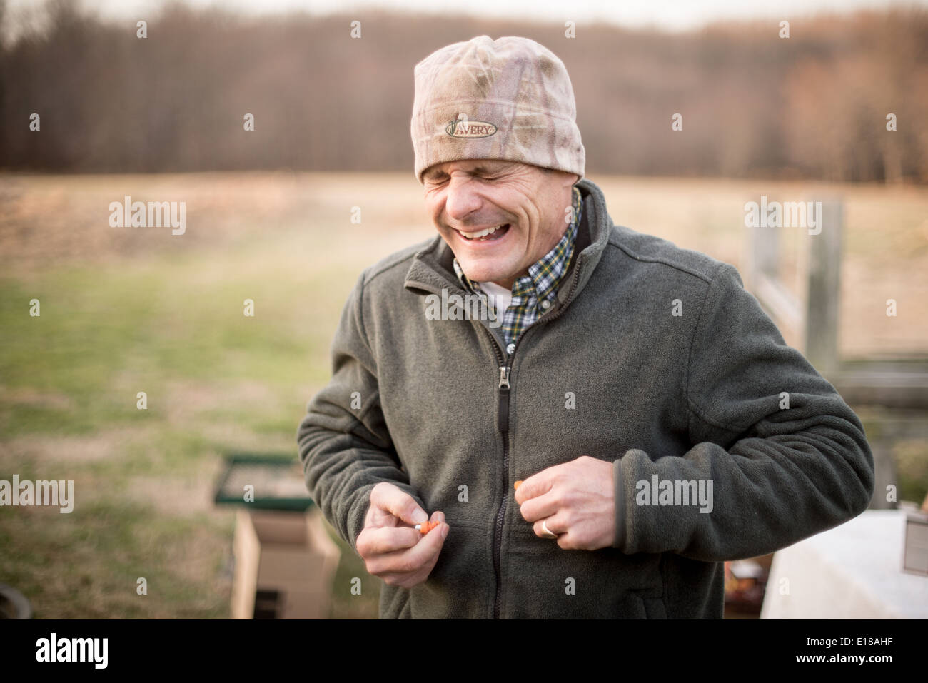 man holding ear plugs wincing after a gun fired in Bel Air, Maryland,USA Stock Photo