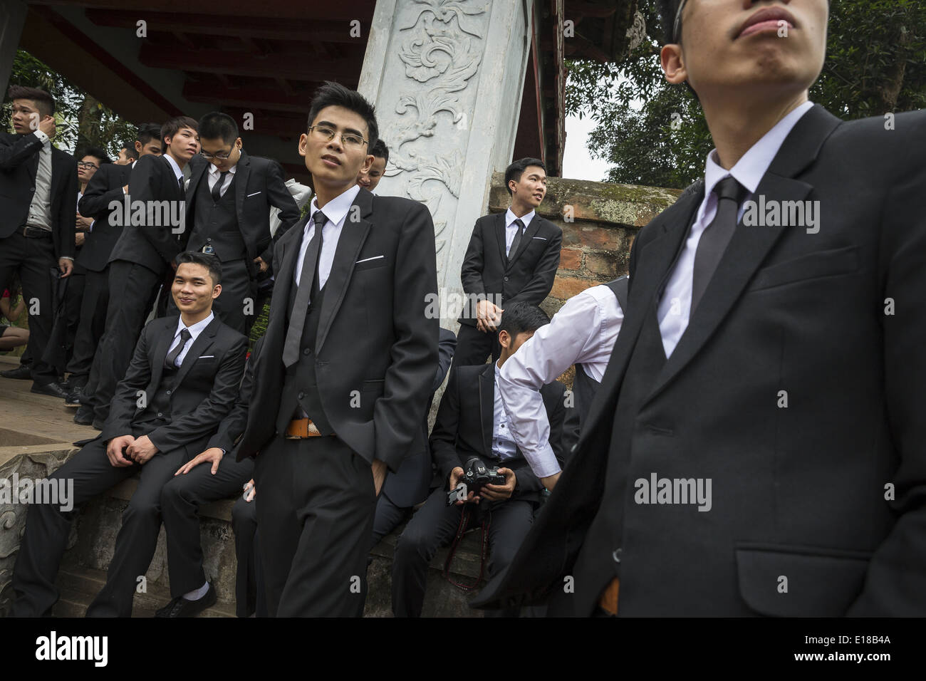 A group of young people wearing in suits waiting to participate in a photo shoot. Stock Photo
