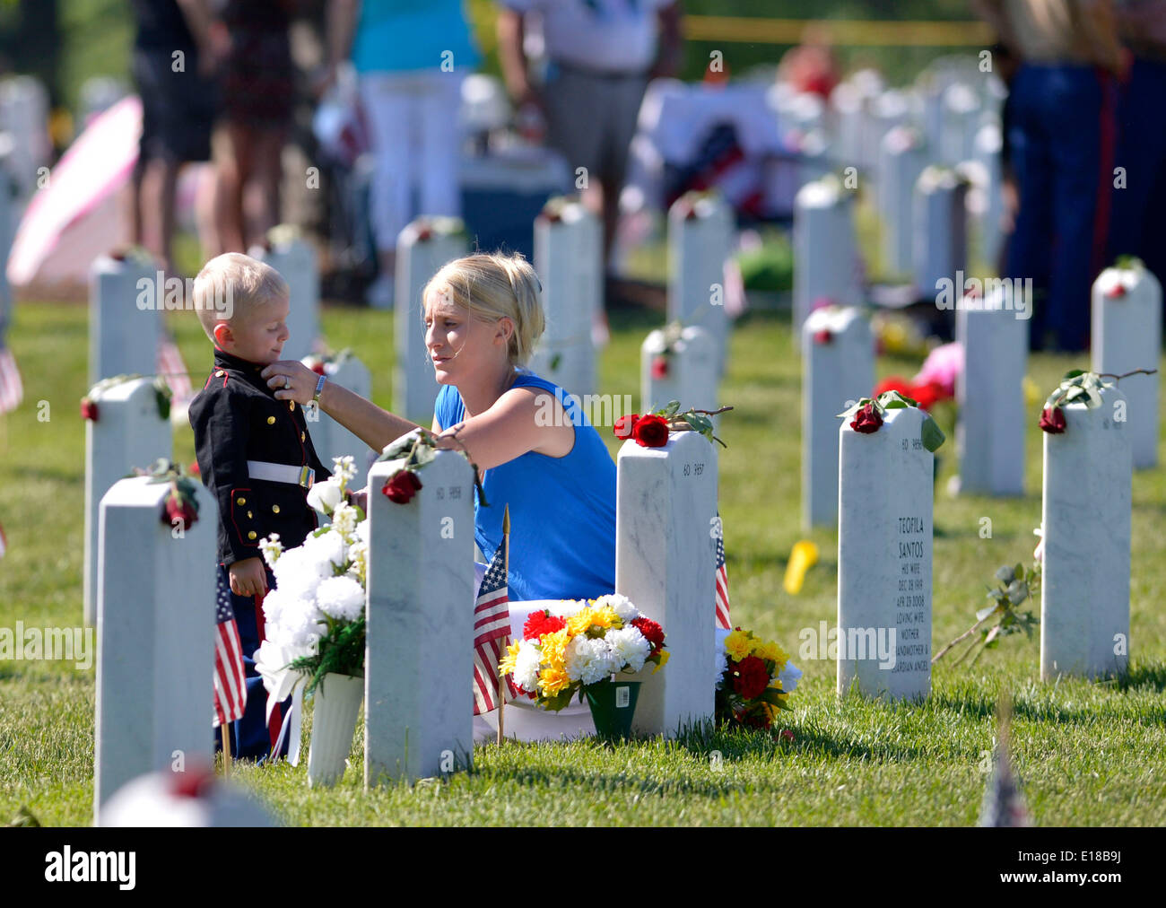 Washington, DC, USA. 26th May, 2014. Brittany and her son Christian mourn for her husband who was killed in Afghanistan in 2011 at the section 60 of Arlington National Cemetery, outside Washington, DC, the United States, May 26, 2014. People crowded in Arlington National Cemetery, especially in Section 60, where America's most recent war deads lie, during the memorial day. Credit:  Yin Bogu/Xinhua/Alamy Live News Stock Photo