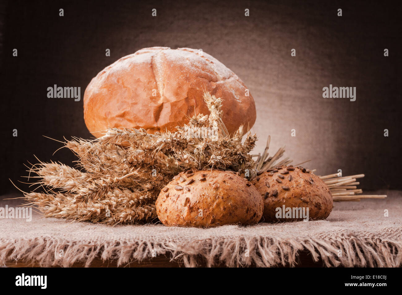 Loaf of bread and wheat ears still life on rustic background Stock ...