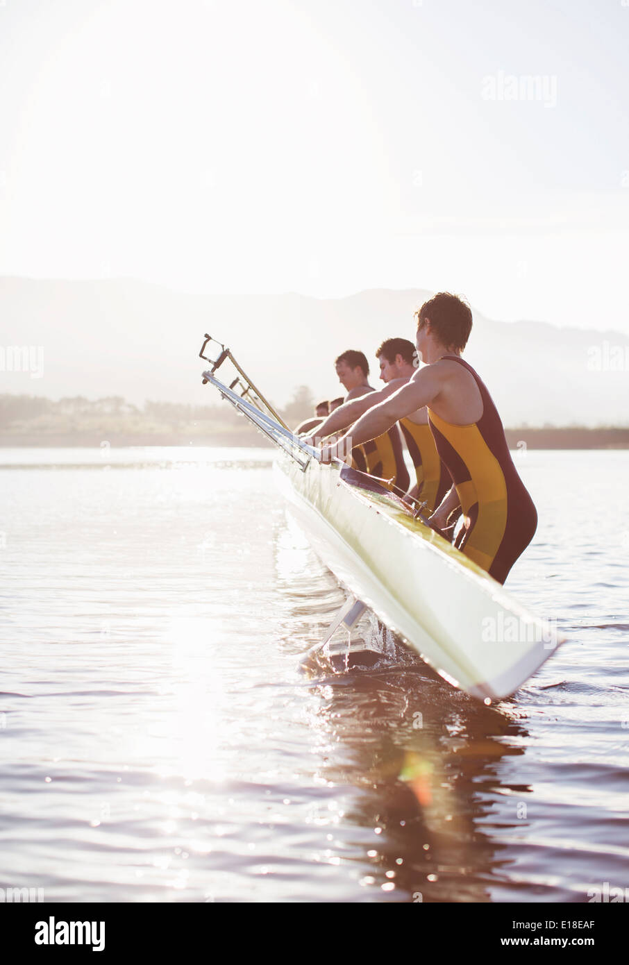 Rowing team placing boat in lake Stock Photo