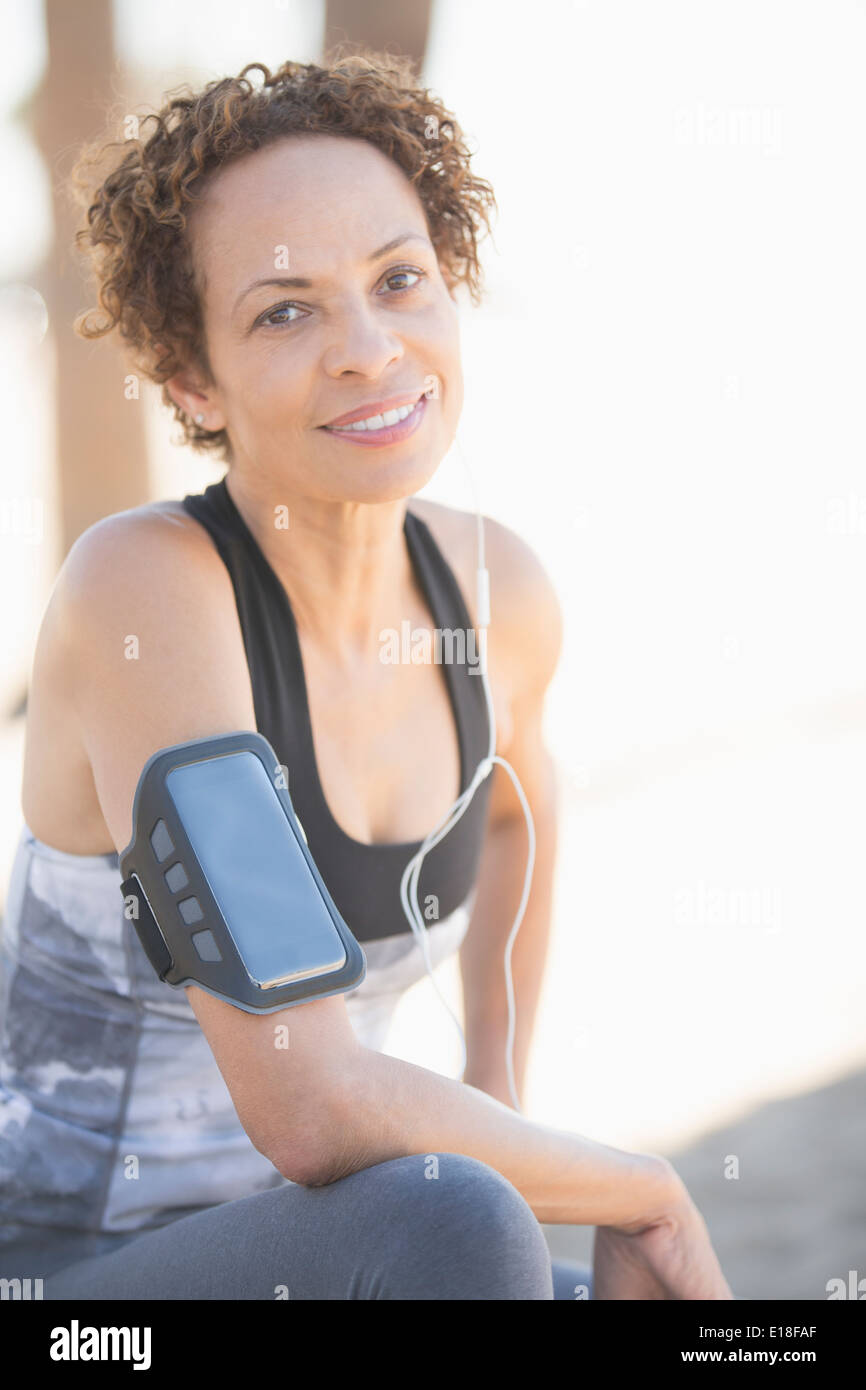 Portrait of confident female jogger wearing arm band Stock Photo