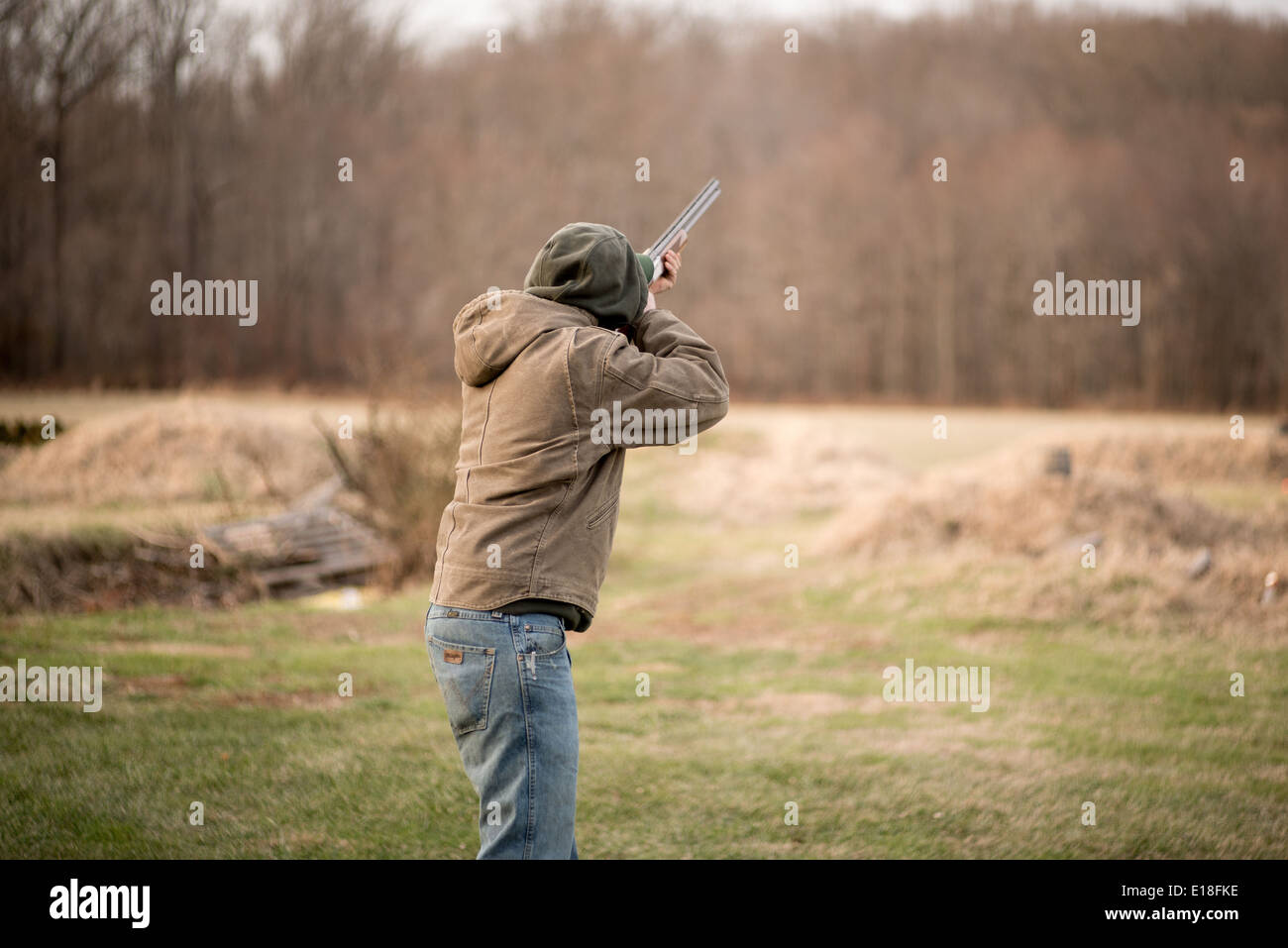 Young man holding rifle, aiming for a clay disc in Bel Air, Maryland,USA Stock Photo