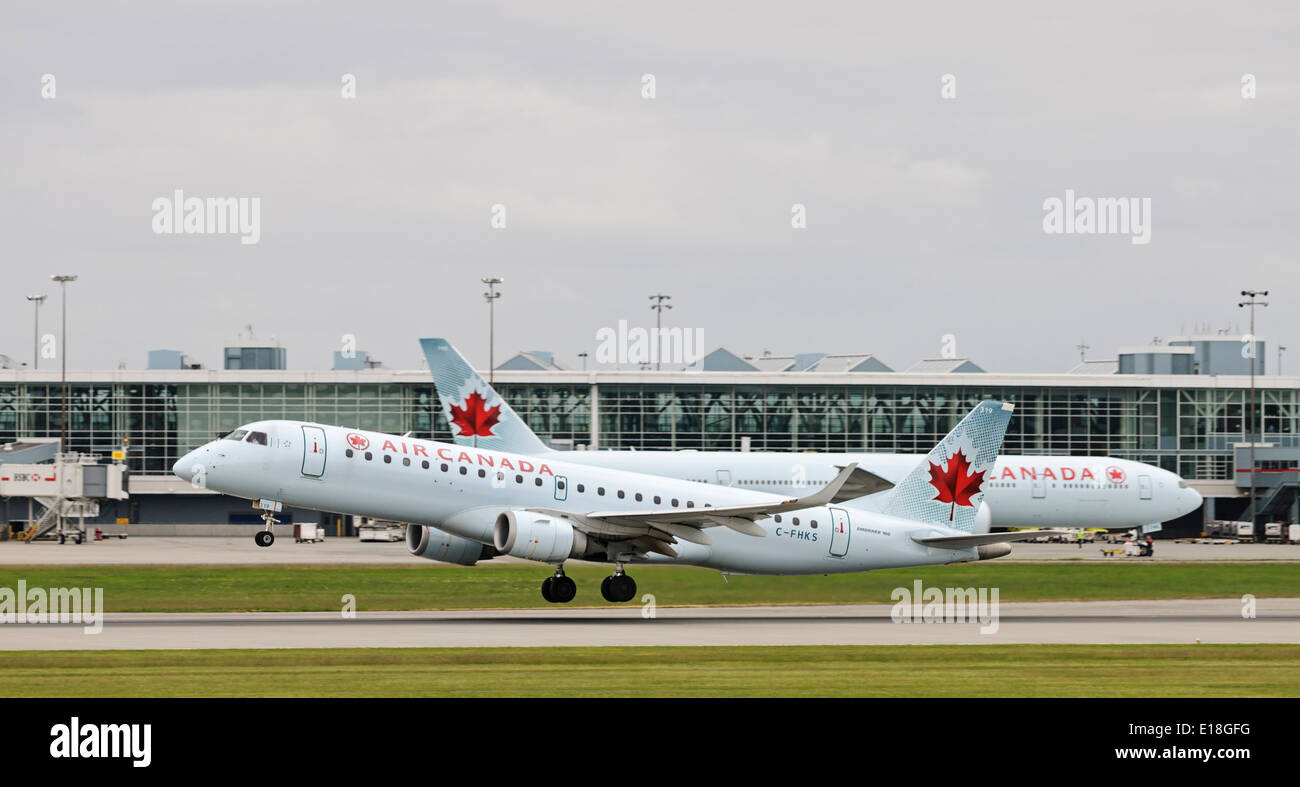 An Air Canada Embraer ERJ-190 (C-FHKS) narrow-body jetliner takes off from Vancouver International Airport Stock Photo