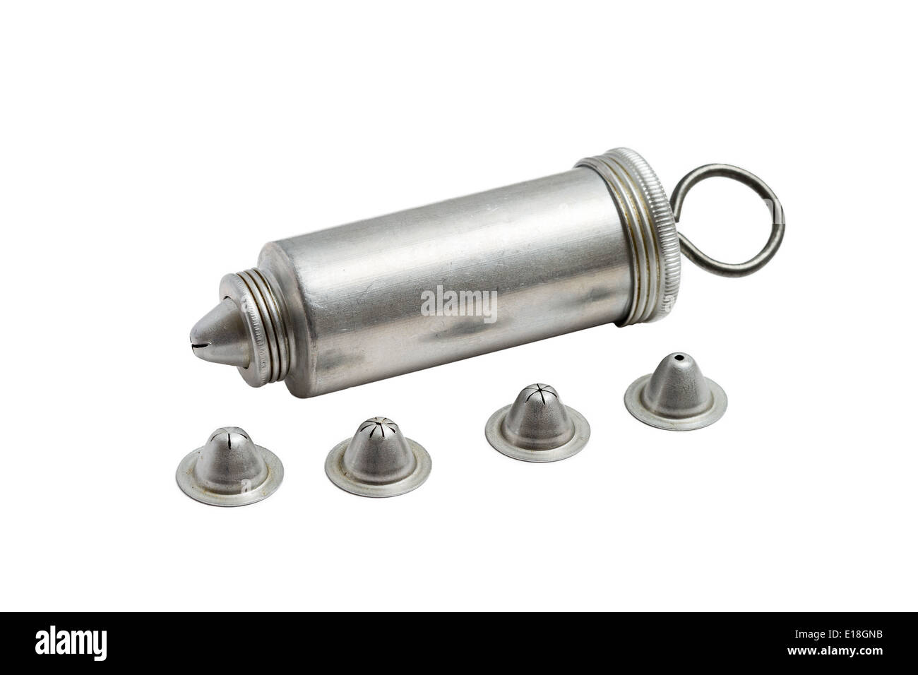 Antique aluminum cake decorator with spare tips on a solid white background Stock Photo