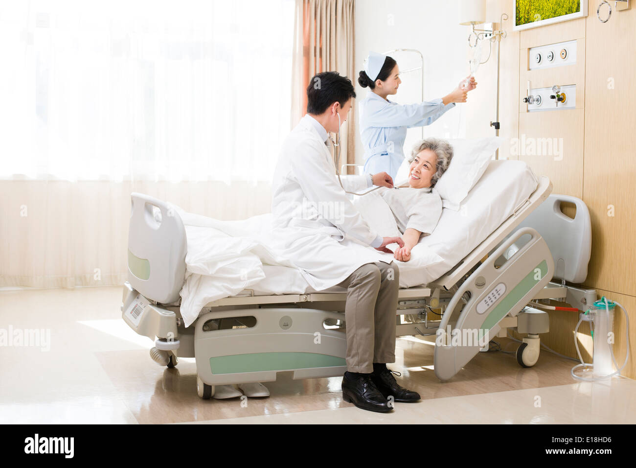 Doctor using stethoscope on patient in hospital Stock Photo - Alamy