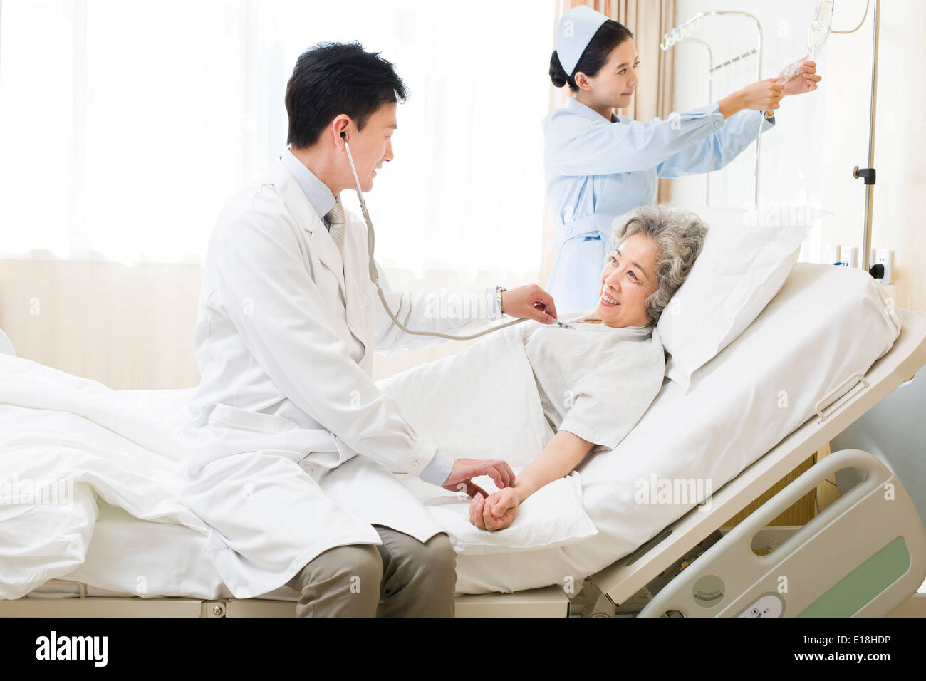 Doctor using stethoscope on patient in hospital Stock Photo - Alamy