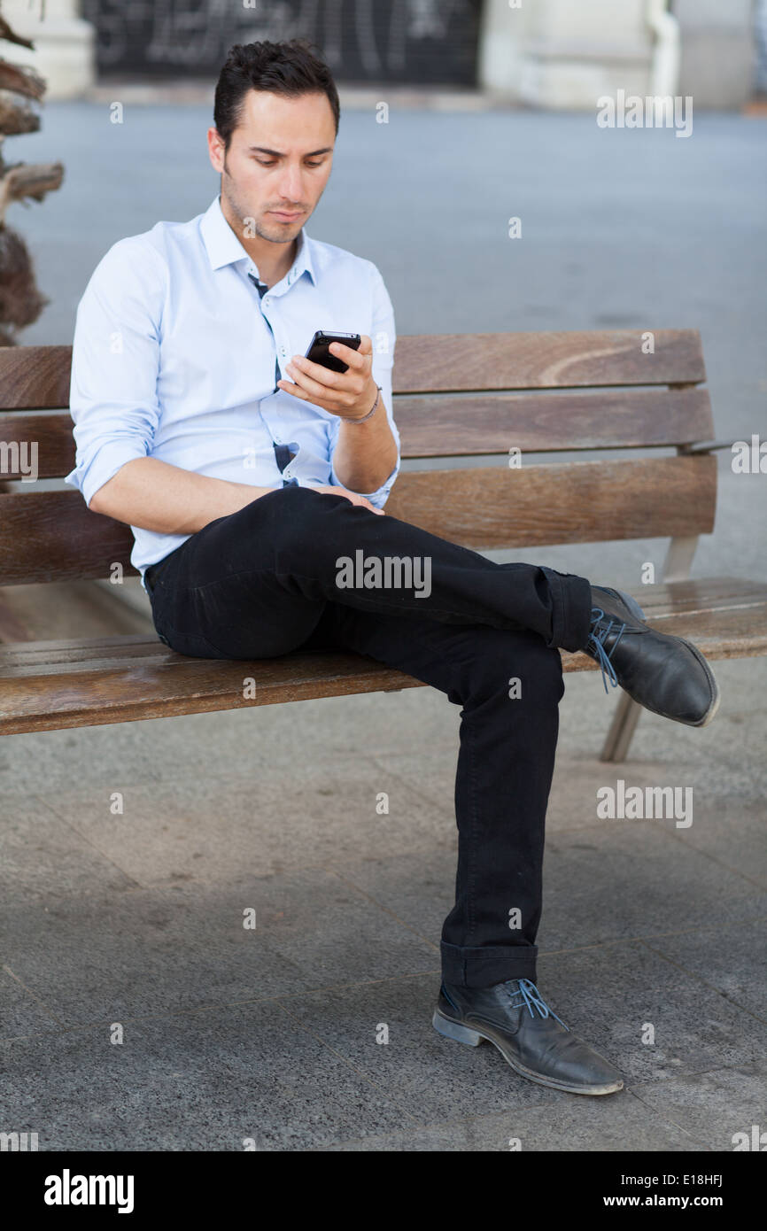 Good-looking man checking his smartphone Stock Photo