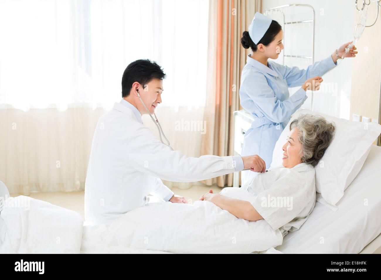 Doctor using stethoscope on patient in hospital Stock Photo - Alamy