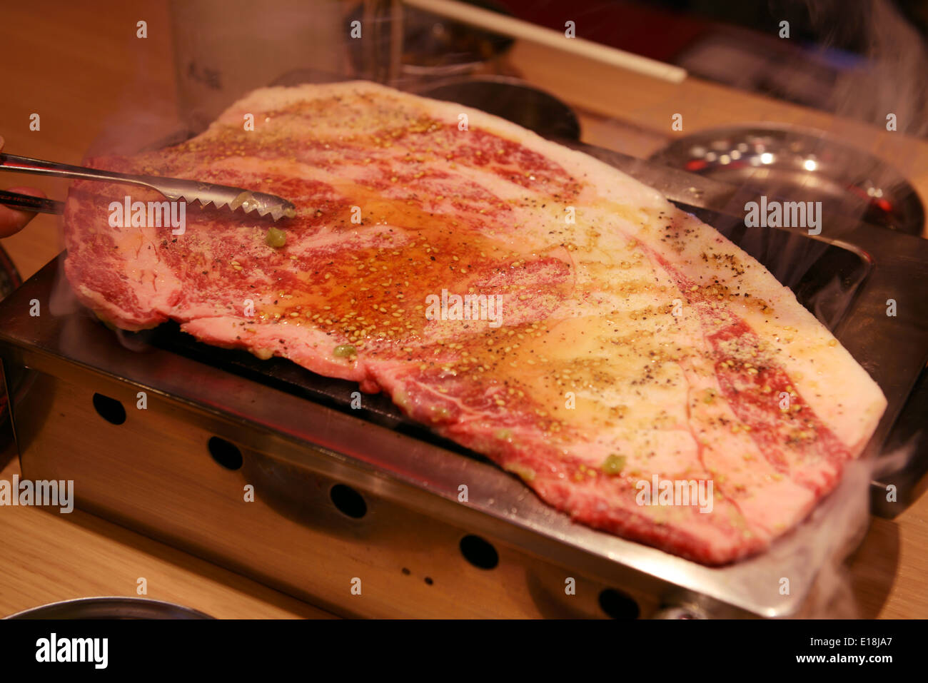 Beef being cooked on a grill stove at a Japanese grill restaurant