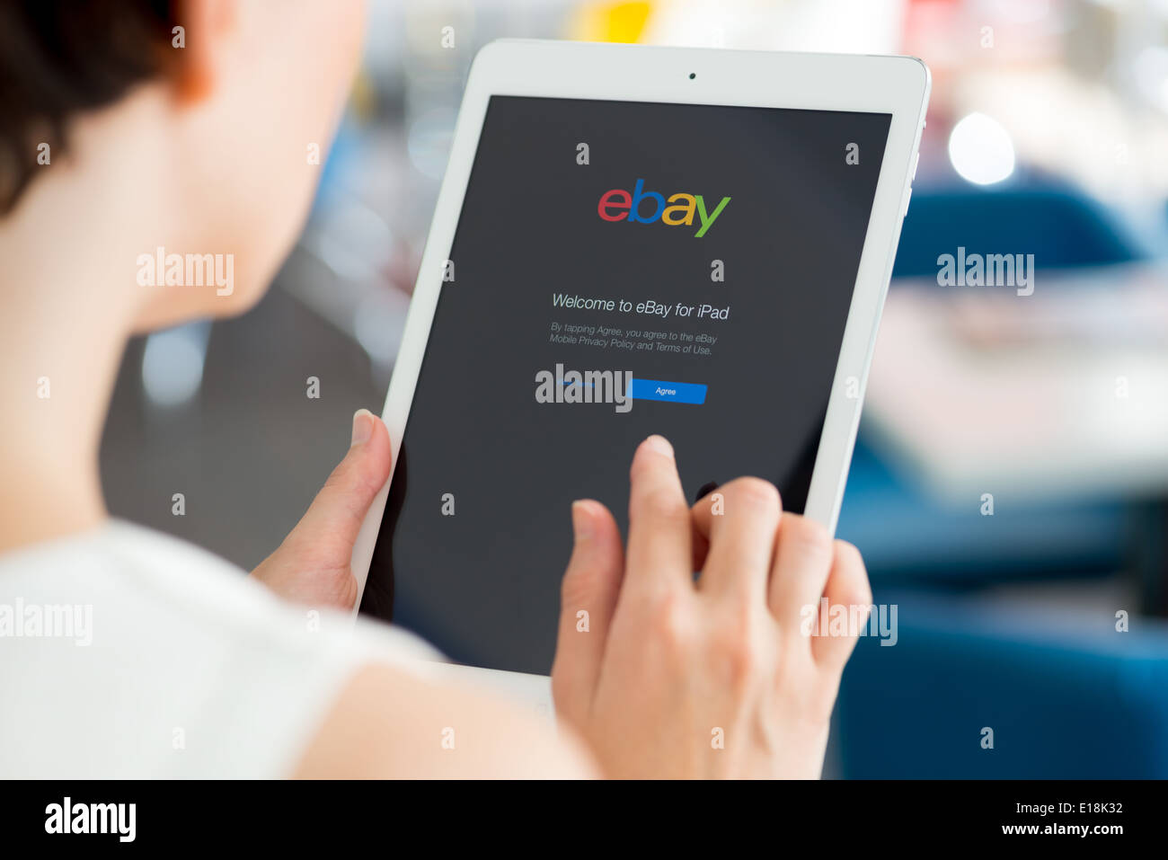 Woman holding a white Apple iPad Air with eBay welcome message on a screen Stock Photo
