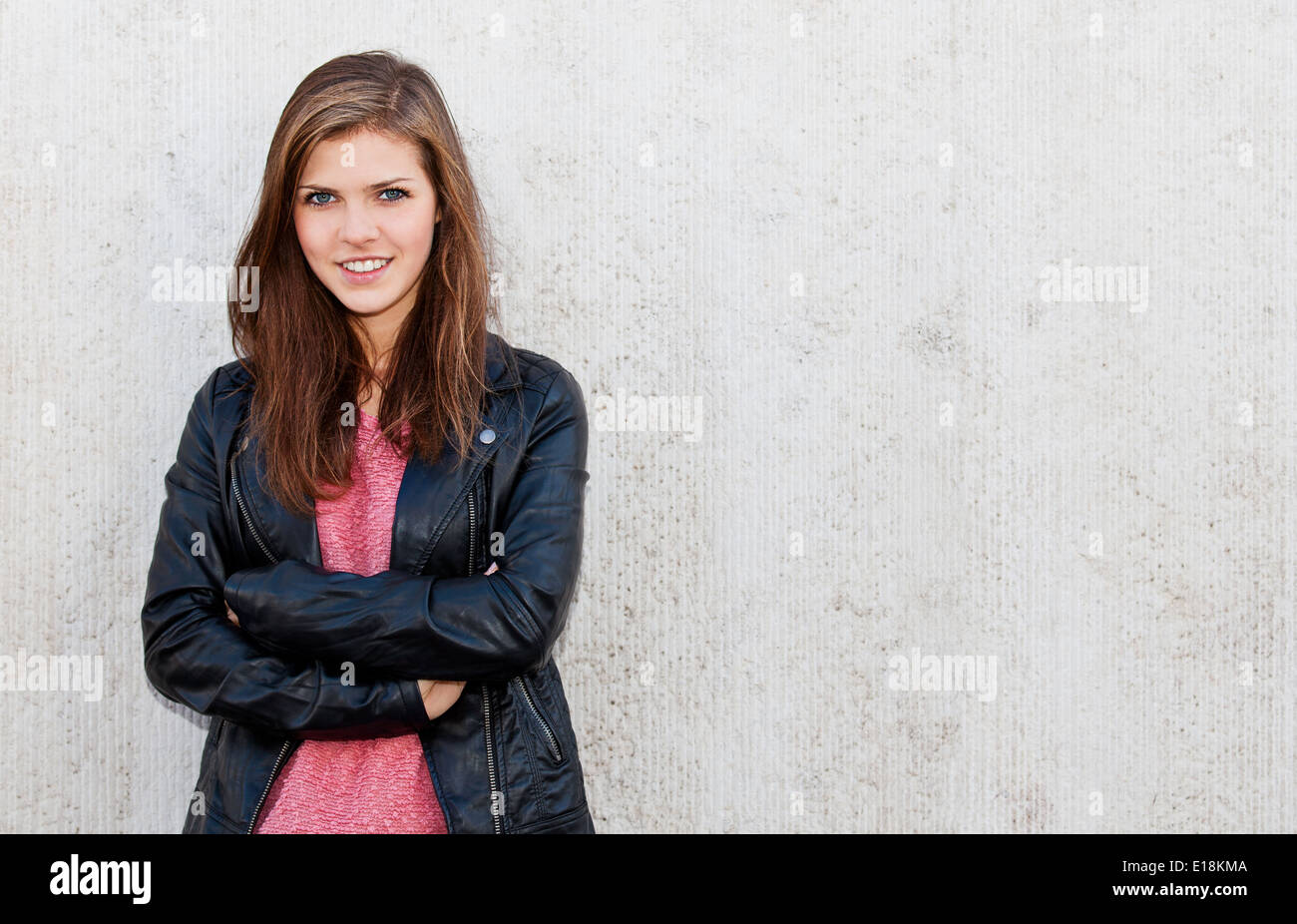 Attractive teenage girl standing in front of concrete background Stock Photo