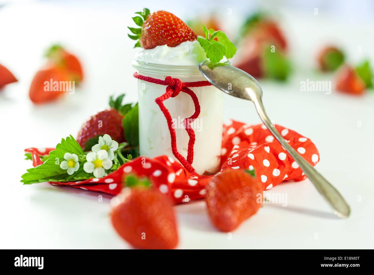 Fresh ripe red farm strawberries with a glass jar of healthy yogurt ...