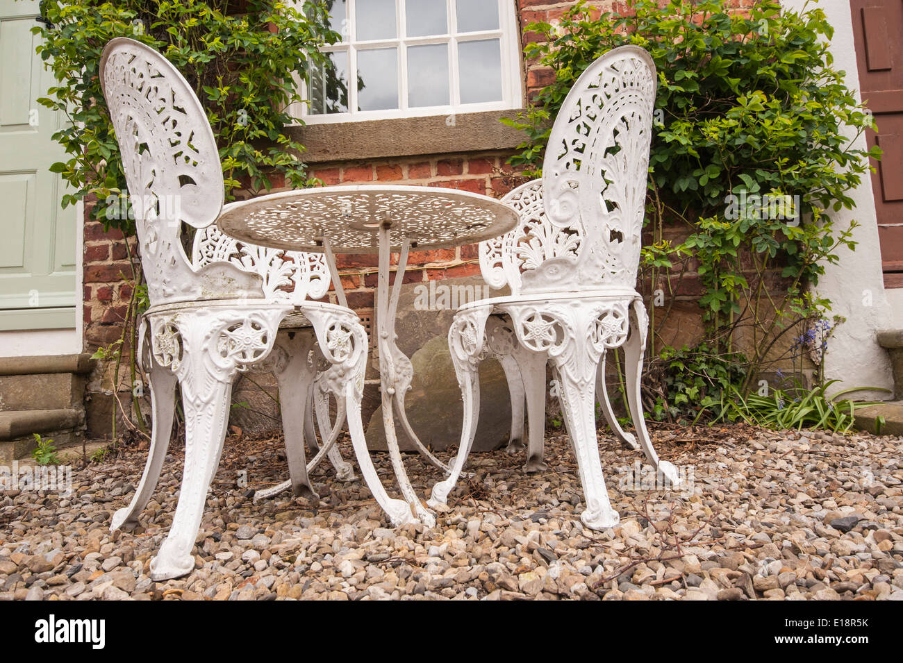 Set of white garden table and chairs on patio outside rural house Stock