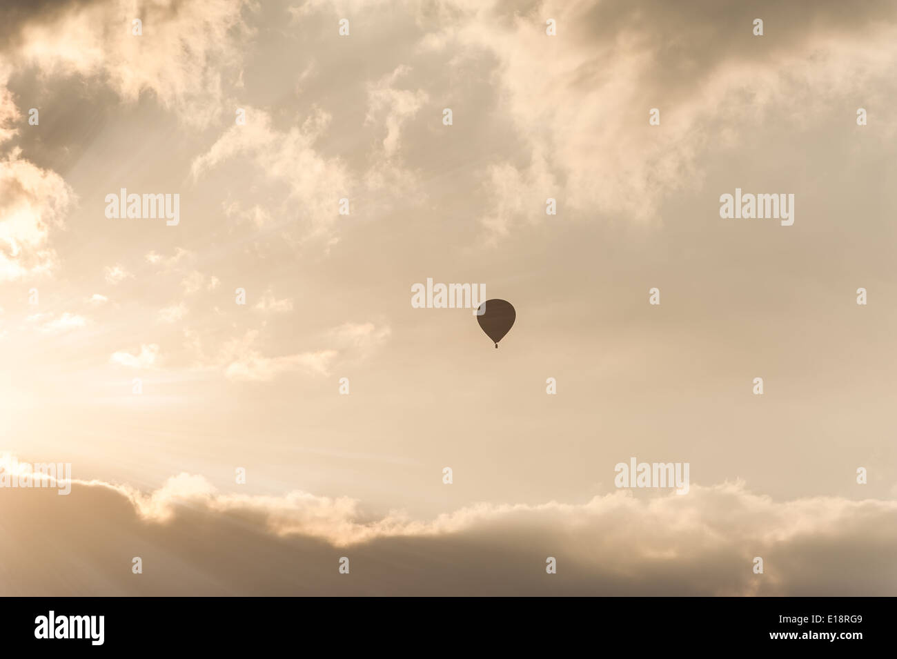 Amazing colors of sunrise with sunbeams over clouds and hot air balloon ...