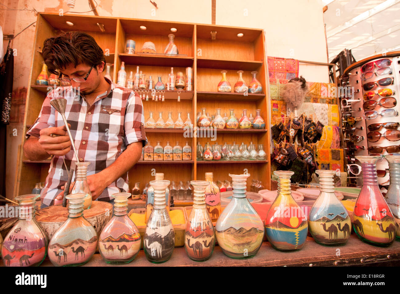 Colour Sand artist fills bottles with colourful desert sand for sale to tourists Photographed in Jerash, Jordan Stock Photo