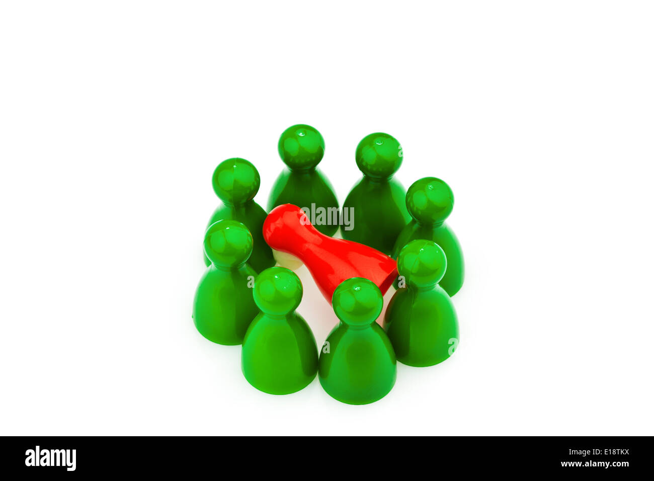 Rote und grüne Spielfiguren. Mobbing, Einsamkeit und Außenseiter im Team. Stock Photo