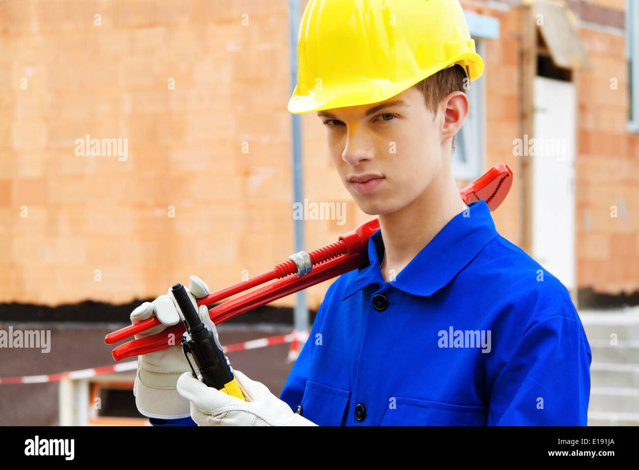 Ein Lehrling / Azubi. Bauarbeiter auf Baustelle mit Helm Stock Photo - Alamy