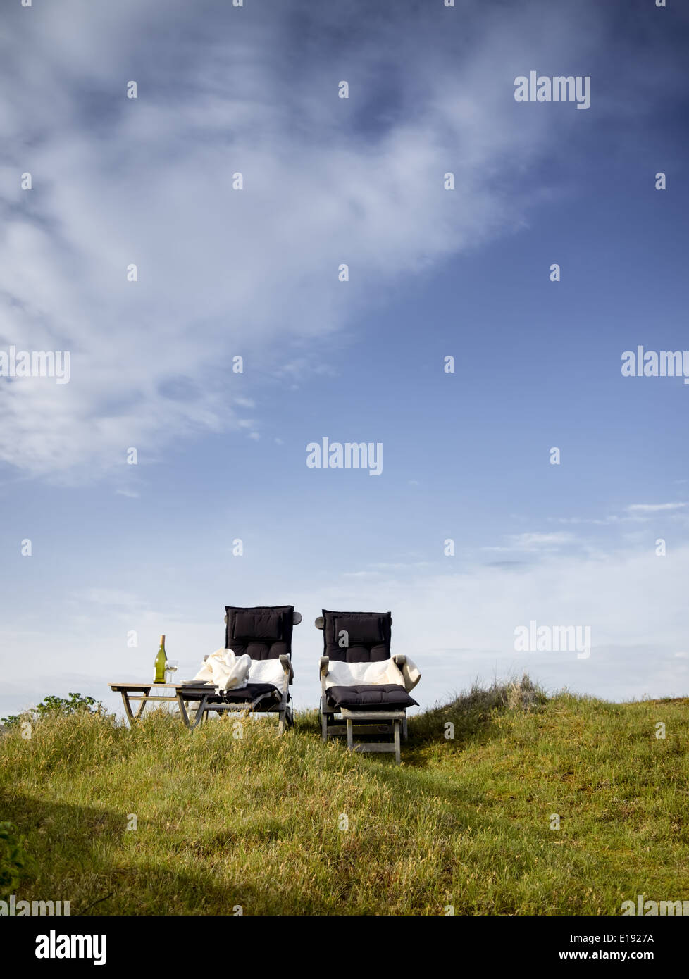 Two relaxation chairs and a glass of wine in the clear day light Stock Photo