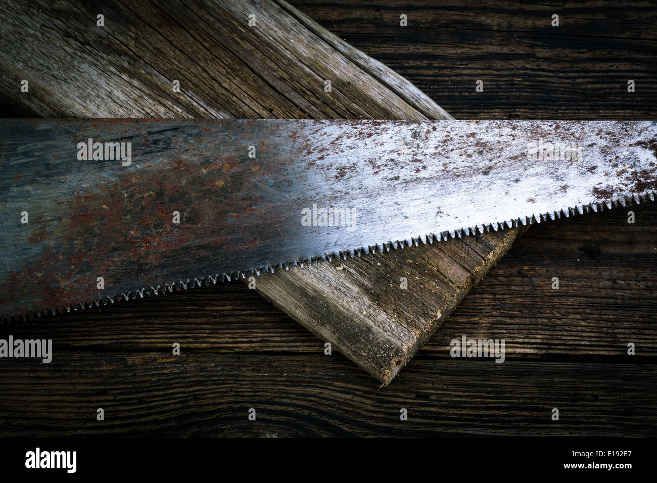 hacksaw and board on wooden background Stock Photo