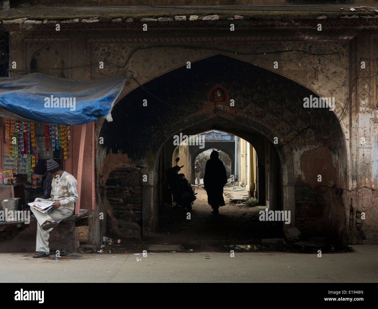 India, Rajasthan, Jaipur, Joshi Colony, man walking through old Mughal style archways Stock Photo