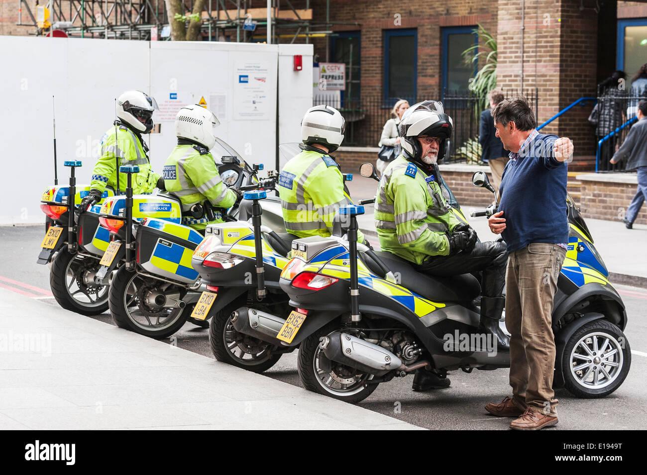 A member of the public asking for directions from a motorcycle policeman. Stock Photo